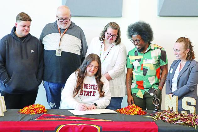 Zoe Newman (center) signs her letter of intent with (L to R) brother Zachary Newman, dad Marty Newman, mom Rhonda Newman, MSU Saxophone Instructor Rafael Powell, and MSU Associate Professor and MPHS alum, Dr. Jennifer Bohannon McGowen COURTESY PHOTO