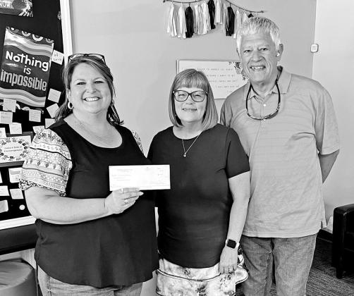 Woody and Karen Ray (far right and center) present a check for $250 from the Pittsburg Rotary Club to Shelly Martinez (left), Operations and Development Associate of the Northeast Texas Child Advocacy Center. COURTESY PHOTO