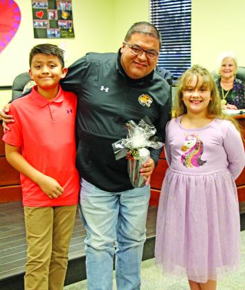 Juan Duenez receives a gift from Cristian DeLaHoya and Isabel Klump from Fowler Elementary