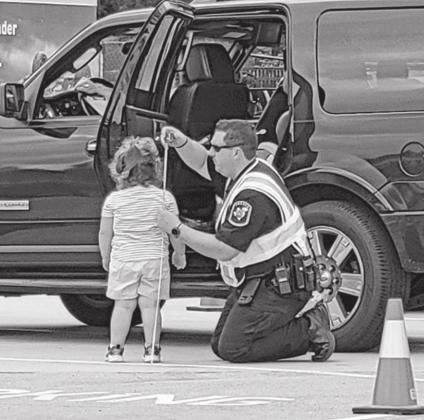 MPISD Officer Brandon Fulcher measures a child to ensure proper seat installation. COURTESY PHOTO