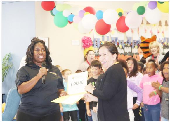 Crystal Jackson presents Carmelita Perez a grant for flexible seating in her classroom at Brice Elementary. COURTESY PHOTO