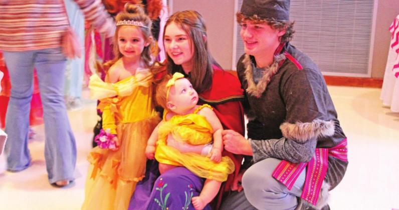 Princess Anna and Kristoff pose with two little ladies.