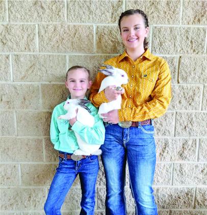 Eastyn Dunn and Analeigh Dunn display their rabbit projects from last year’s Titus County Fair.