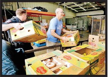 It was a wonderfully-busy morning at Titus County Cares as another delivery of produce also arrived, and volunteers were able to help unload. COURTESY PHOTO