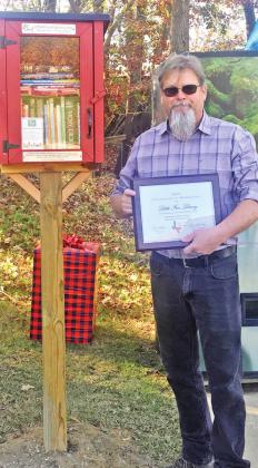 Bryan Freisth stands near the new Little Free Library. The books are available for one and all. TRIBUNE PHOTO / ELIZABETH LANNING