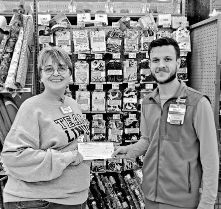 Chapter president Debra Beaumont gratefully accepts a donation from Walmart in Mt. Pleasant for Project Linus. COURTESY PHOTO