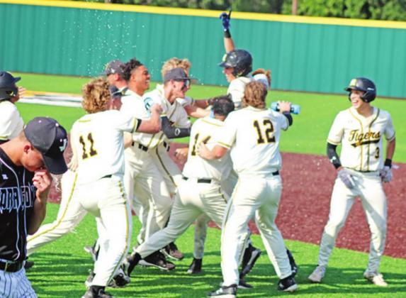 The Mount Pleasant Tigers mob Jacob Bristow after his walk-off RBI single in game two of their bi-district series against Nacogdoches. Unfortunately, the Tigers fell in the series, 2-1. TRIBUNE PHOTO / QUINTEN BOYD