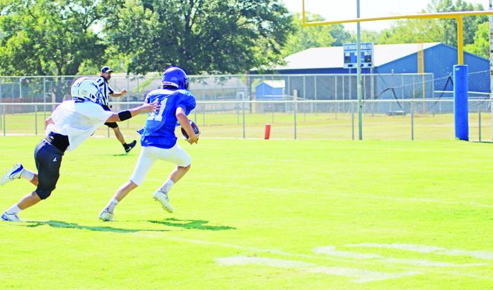 TRIBUNE PHOTO / QUINTEN BOYD Rivercrest’s Cason Fields breaks away from a Detroit defender during Saturday’s scrimmage. Fields would score on the play. The Rebels will scrimmage Maud and Ore City Thursday at the Swamp.
