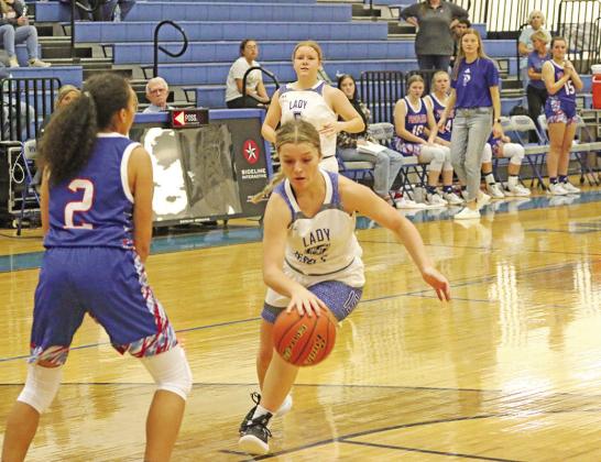 Rivercrest’s Logan Huddleston drives toward the basket as Prairiland’s Randee Maull sets up defensively. The Lady Rebels battled back in Tuesday’s game but fell short, 59-54. TRIBUNE PHOTO / QUINTEN BOYD