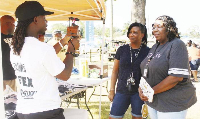 Kaymon Farmer videos two ladies during the annual Tailgate Party in Pittsburg and asks them what makes Friday Night Lights special to them personally. GAZETTE PHOTO / ELIZABETH LANNING