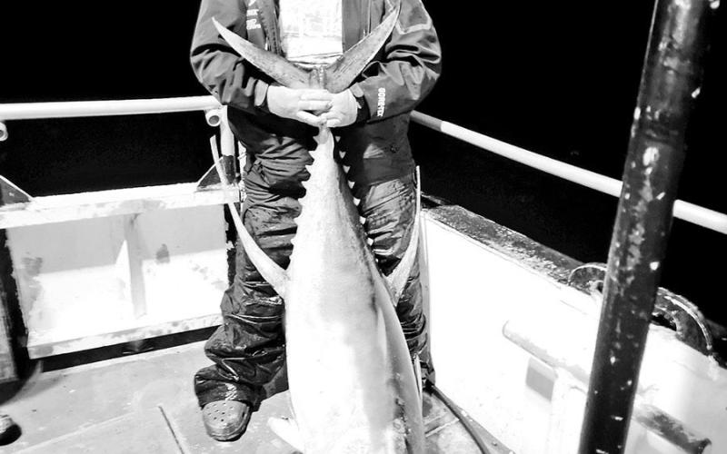 Jason Barber with the 110-pound yellowfin tuna he caught on a topwater plug around Hoover Diana platform, roughly 130 miles offshore from Port Aransas. COURTESY PHOTO / JASON BARBER