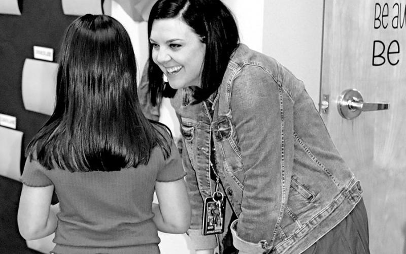 Annie Sims teacher Natalie White speaks to one of her former students about her summer.