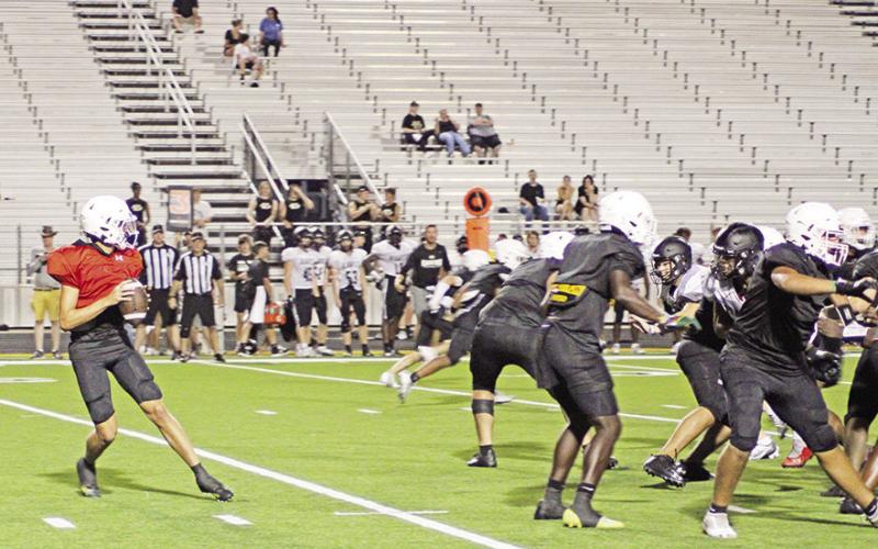 Mount Pleasant’s Mason McMinn drops back to pass during last week’s scrimmage against Pleasant Grove. The Tigers open their season Friday at Sam Parker Field against Pittsburg.