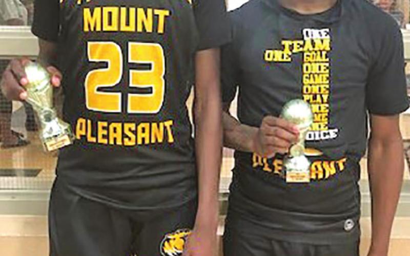 Freshman guard Reggie Webster (L) and junior guard Kelcey Morris (R) pose with their all-tournament trophies. COURTESY PHOTO / DREW BARKLEY