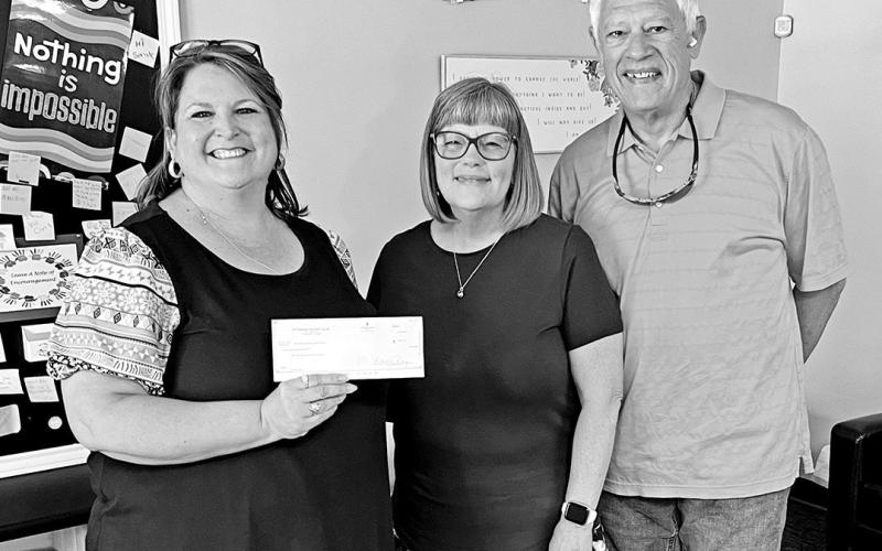 Woody and Karen Ray (far right and center) present a check for $250 from the Pittsburg Rotary Club to Shelly Martinez (left), Operations and Development Associate of the Northeast Texas Child Advocacy Center. COURTESY PHOTO