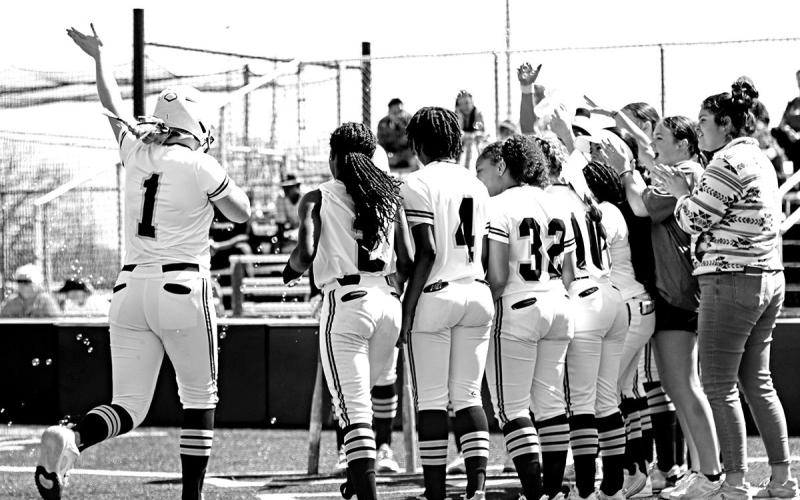 Her team waits at home plate to celebrate Kammie Terrell’s towering home run.