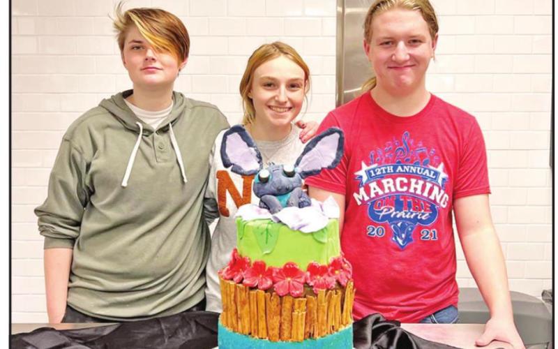 L to R: Rian Richie, Amanda Brewer, and Brian Bush with their “Lilo and Stitch” themed cake. Not pictured Katherine Counce. COURTESY PHOTOS