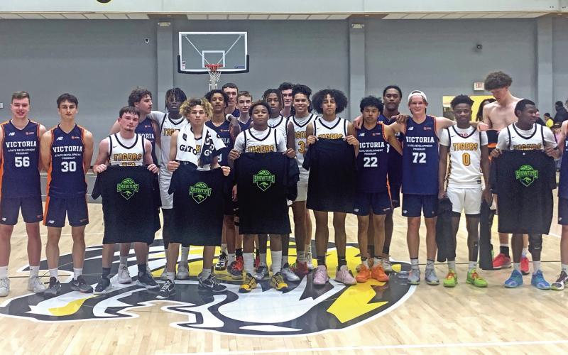 The Mount Pleasant Tigers and Basketball Victoria’s varsity boys team stand together for a picture after their game Tuesday evening. The 13th-ranked Tigers picked up the win, 58-46. TRIBUNE PHOTO / QUINTEN BOYD