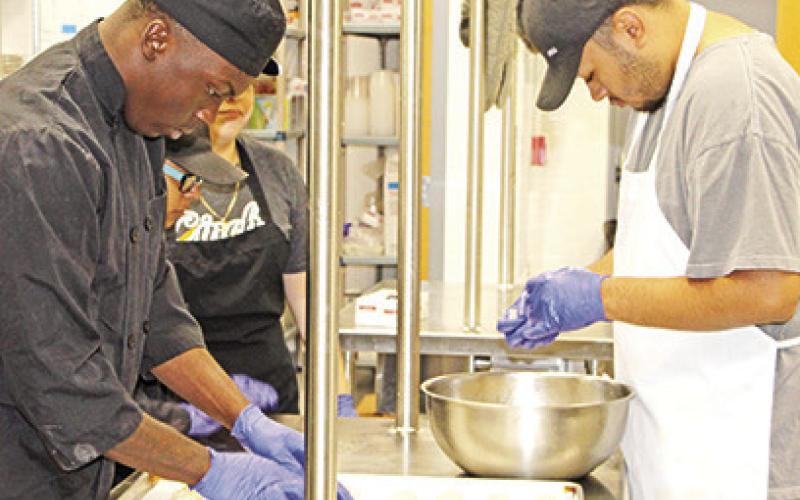 Kelcey Morris and Delfino Hernandez prepare Italian breadsticks
