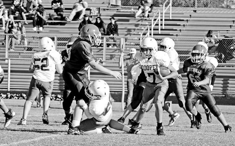 Rivercrest seventh grade football players Beck Perkins (left) and Cash Carroll chase down a Cooper running back during Thursday’s game. The seventh grade Rebels fell to the Bulldogs, 14-0.