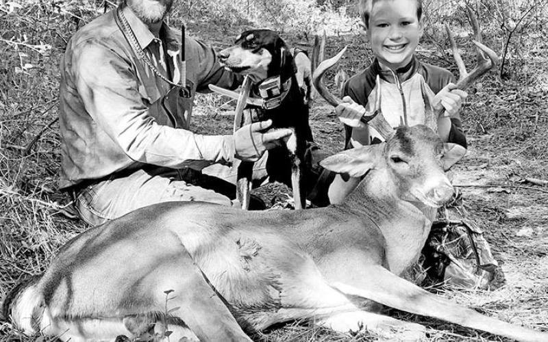 Jeff Glende with (left) and his hound/cur mix “Dago,” have teamed up to recover dozens of bucks for Texas and Louisiana deer hunters. Like many dog handlers, Glende loves seeing the smile on a youngster’s face when they learn a lost deer has been found. (Courtesy Photo, Jeff Glende)