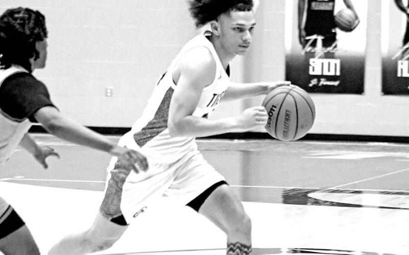 Moving Swiftly Down Court Mount Pleasant’s Carter Chism (24) dribbles past a Texas High defender during a recent home game. The Tigers defeated Marshall 66-44 last week to improve to 10-1 in District 10-5A action and 21-4 overall.
