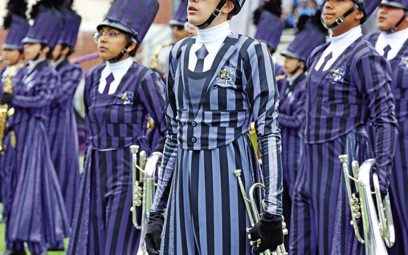 Drum Major, Orion Senence (center), prepares to play the trumpet with the band