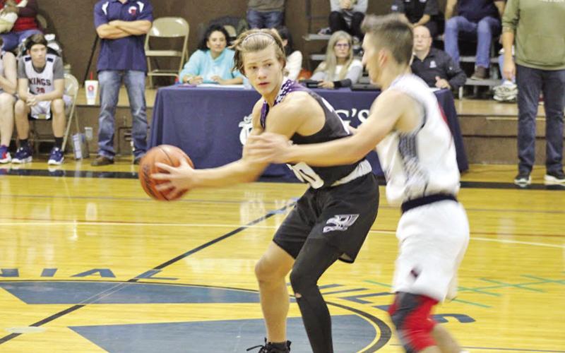 CHAAMP’s John Luke Angier holds the ball with his back to an approaching Kings Academy defender. COURTESY PHOTO