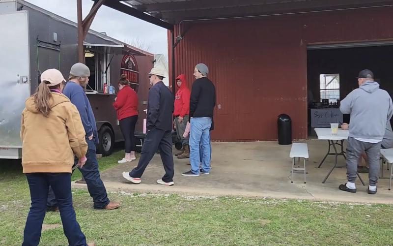 Guests wait in line at a food truck.