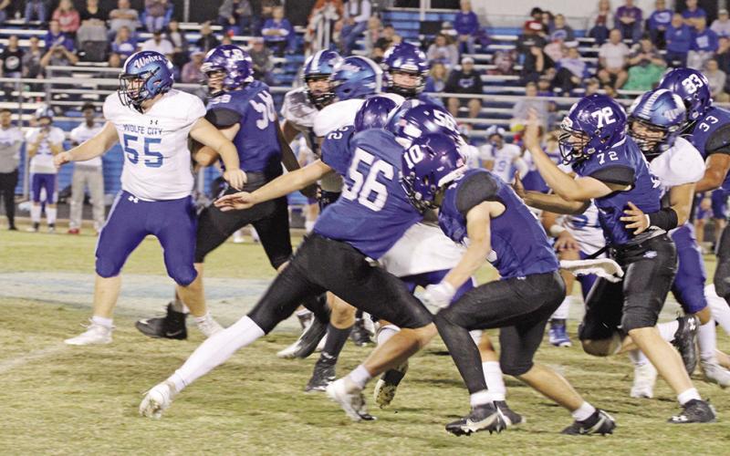 Rivercrest’s Noah Altal (#56), Connor Herring (#10) and Dalton Lovett (#22) corral a Wolfe City running back during Thursday’s game. The Rebels will take on Beckville in the bi-district round of the playoffs next week. TRIBUNE PHOTO / QUINTEN BOYD