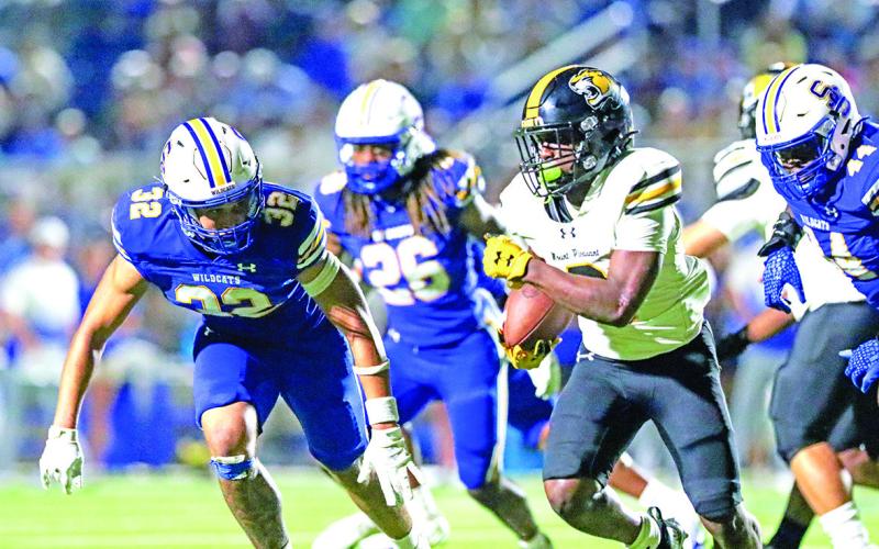 Tony Grant finds the edge against a swarm of Wildcat defenders. Grant led the Tiger rushing attack with 137 yards on the ground.