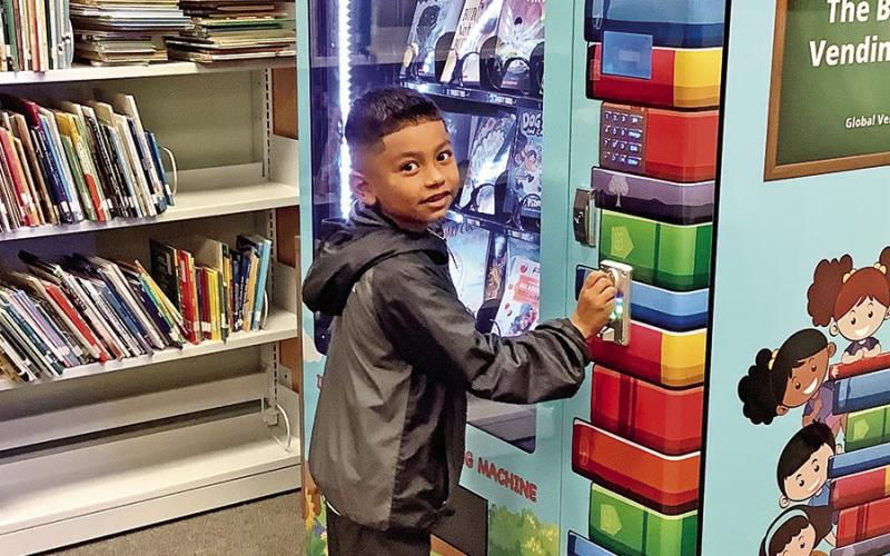 Second-grader Fidel Memije selects his new book