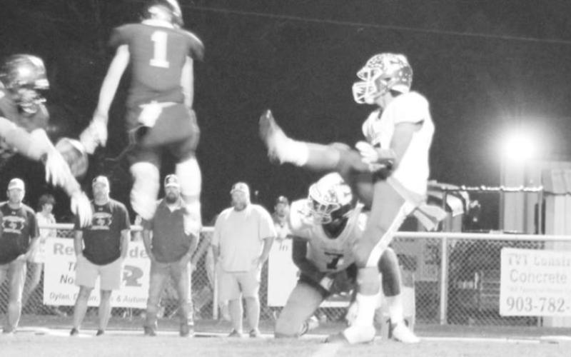 Carson Whitley (center) and Connor Young jump to block an extra point during Friday’s game.