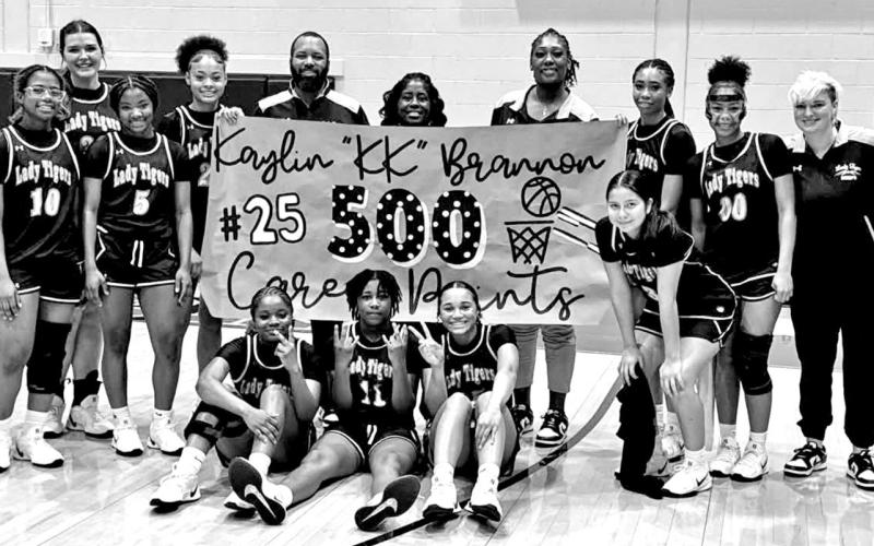 Kaylin Brannon with the Lady Tigers and coaches as they celebrate a huge milestone.