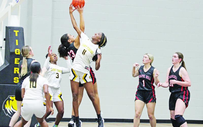 Mount Pleasant’s Aziyah Farrier and Chapel Hill’s Mackenzie Espinoza battle for a rebound during Tuesday’s season opener. The Lady Tigers defeated the Lady Devils, 57-36. TRIBUNE PHOTO / QUINTEN BOYD