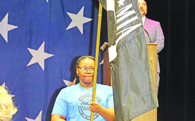Wallace student, Dream Veasley, presents the POW-MIA flag during a moment of silence