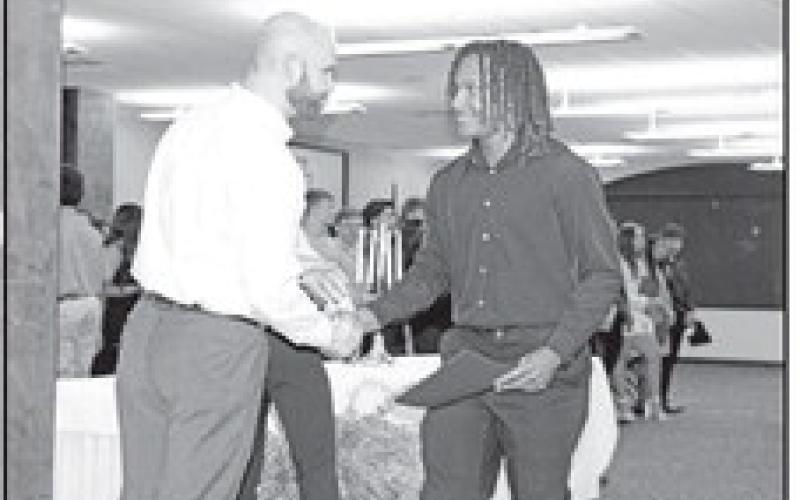 MPHS Principal, Craig Bailey, congratulates junior Jonathan Turner