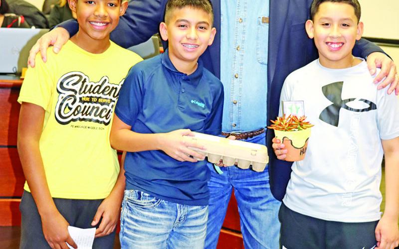 Wallace Student Council Vice President Ulisses Mata (left), NEHS president Kelvin Garcia (center) and Student Council President Jimmy Aguilar (right) with Buddy Blue
