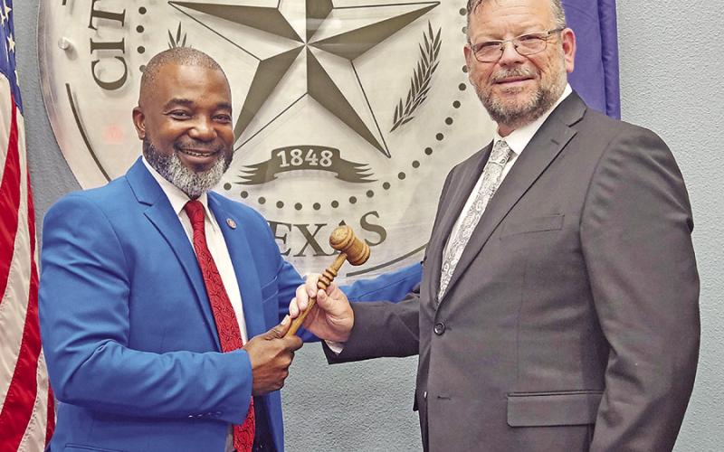 Tracy Craig hands over the gavel to Wesley Lyon as welcome of the new mayor TRIBUNE PHOTO / NICOLE KIMBALL