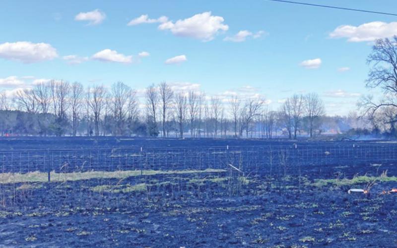 The photo on the left shows the view from FM 1735, just south of the intersection with FM 4000. On the right, firefighters extinguished the last of the fire on local resident Leslie Brosnan’s land. TRIBUNE PHOTOS / DI ANA FITZGERALD