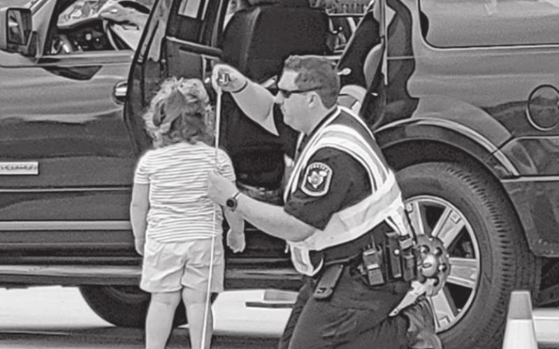 MPISD Officer Brandon Fulcher measures a child to ensure proper seat installation. COURTESY PHOTO