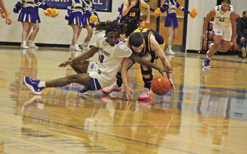 Harts Bluff’s Avyn Carrington (right) battles with Rivercrest’s Cameron Lowe (left) for a loose ball during Wednesday’s district game. The Rebels held on for a 39-36 win over the Bulldogs.