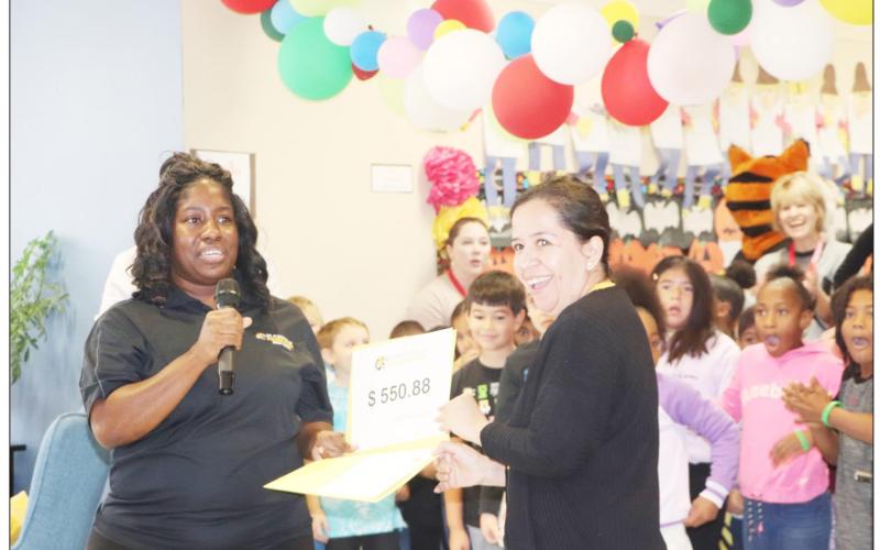 Crystal Jackson presents Carmelita Perez a grant for flexible seating in her classroom at Brice Elementary. COURTESY PHOTO