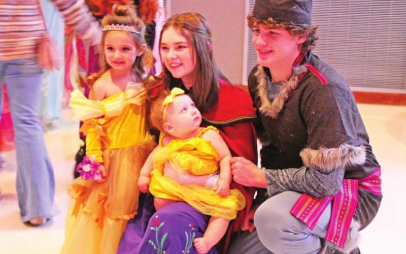 Princess Anna and Kristoff pose with two little ladies.