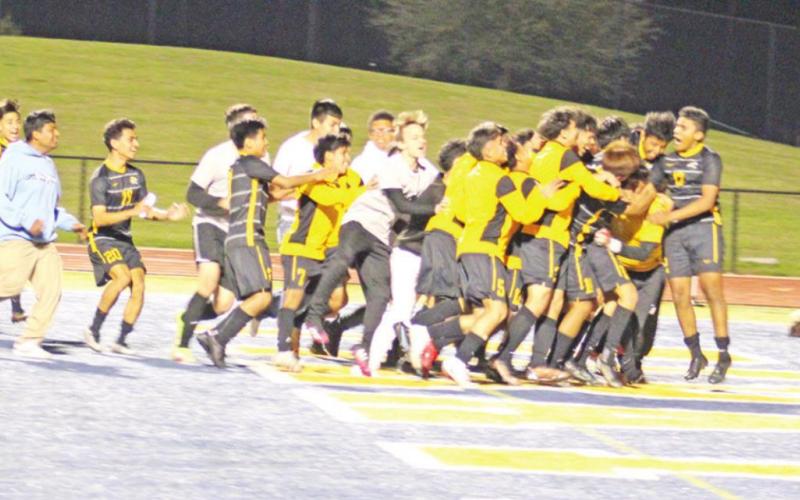 The Mount Pleasant soccer team mobs goalie Bobby Gandara after his save in penalty kicks that clinched the win for the Tigers. TRIBUNE PHOTOS / QUINTEN BOYD