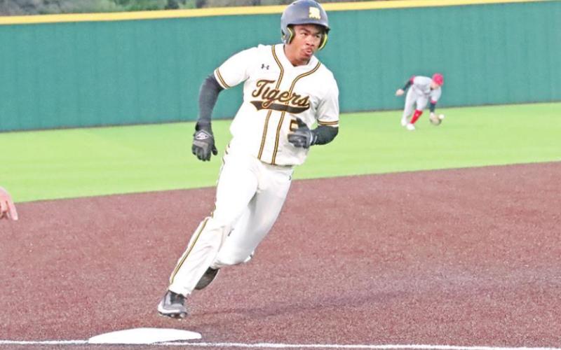 Tyson Minter rounds third trying to beat the throw from center.