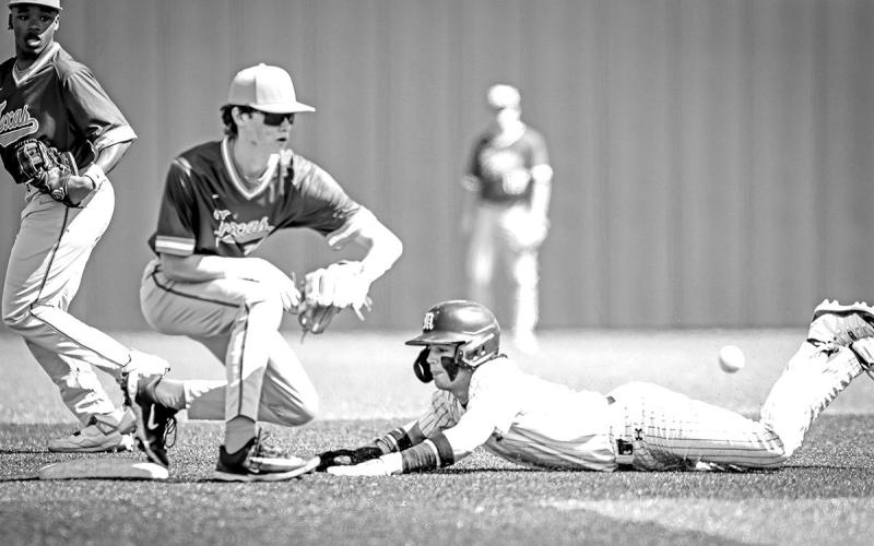Dax Price dives into the bag and beats the throw to second base.