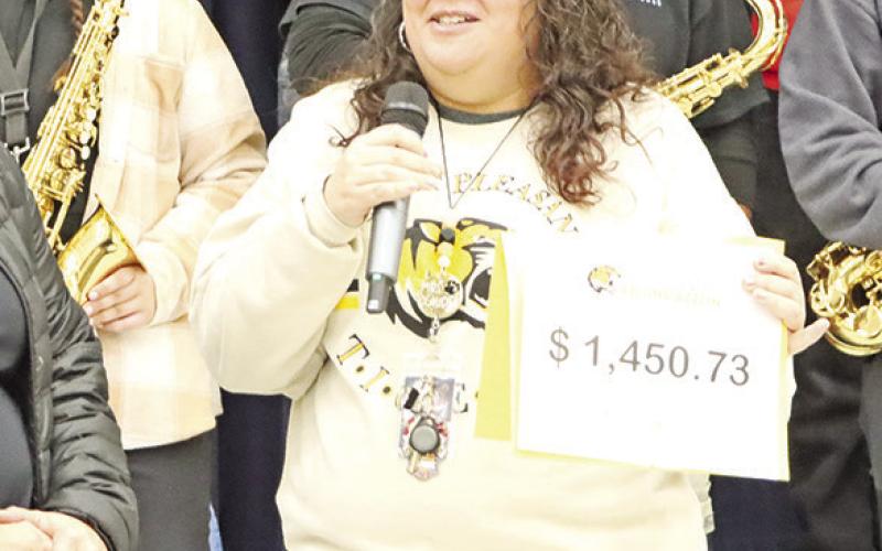 Claudia Klump (right) tells the audience at Vivian Fowler that she will use her $1,450.73 grant for a smart TV, sound bar, Apple TV Box and wall mount