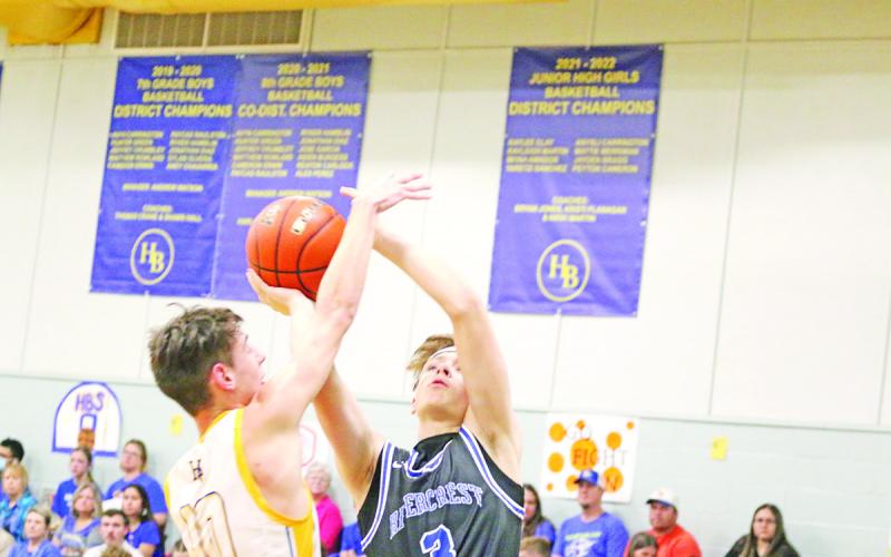 Rivercrest’s Cayden Williams and Harts Bluff’s Matthew Rowland battle under the basket during Tuesday’s game. The Bulldogs picked up the win over the Rebels, 50-42. TRIBUNE PHOTOS / QUINTEN BOYD