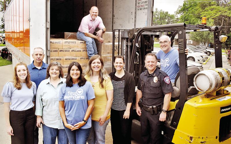 On hand to assist in the truck’s delivery on May 10 were from left to right: From left: Mount Pleasant City and The Church of Jesus Christ Latter-day Saints leaders Diana Bonney, Jack Jones, Sherri Spruill, Kim Hedges, Melissa Moulton, Kellie Richins, Mark Buhman, and Rob Holliday. Brandon Dodd is in the truck. Not pictured: Mount Pleasant City Manager Ed Thatcher and Mount Pleasant LDS member Joanne Christian. COURTESY PHOTO